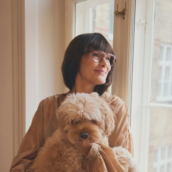 En kvinde med briller sidder sammen med en hund