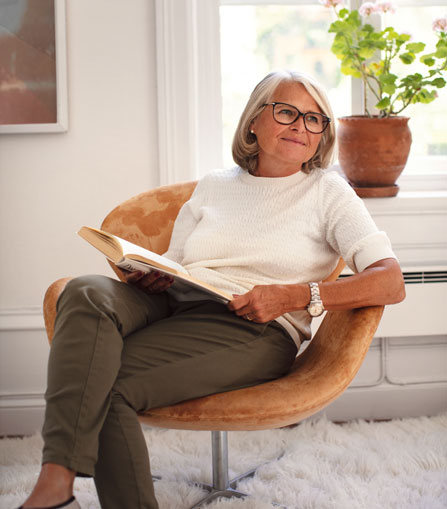 Seniorkvinna som sitter i fåtölj